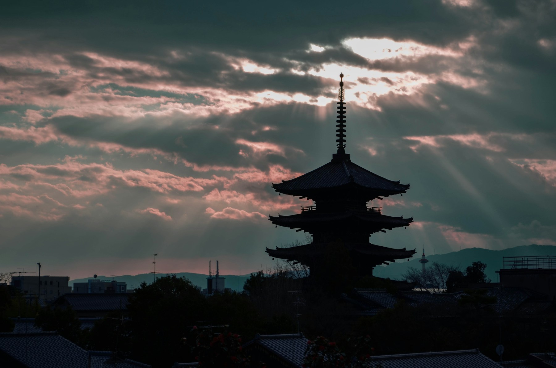 A pagoda silhouetted against a dramatic evening sky