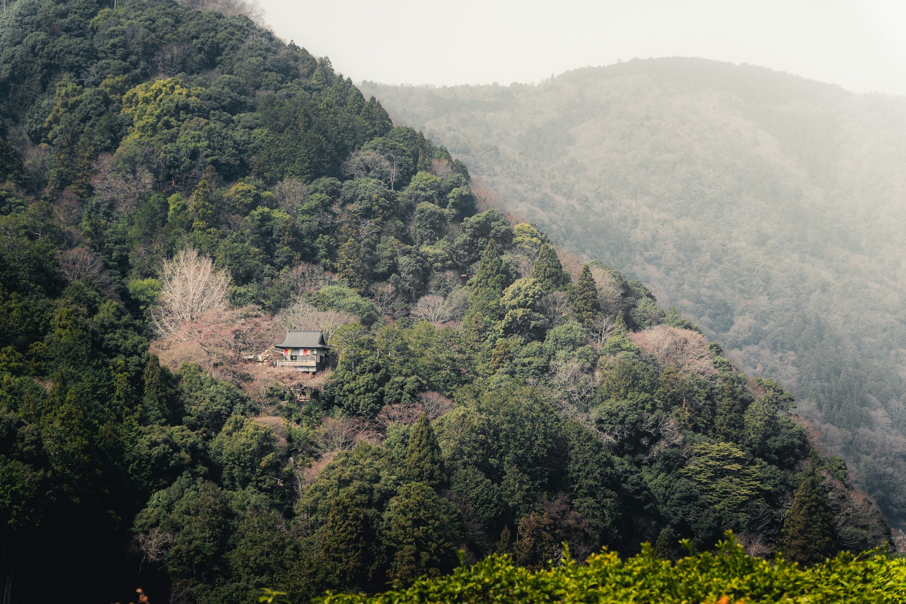 A secluded building surrounded by forested mountains